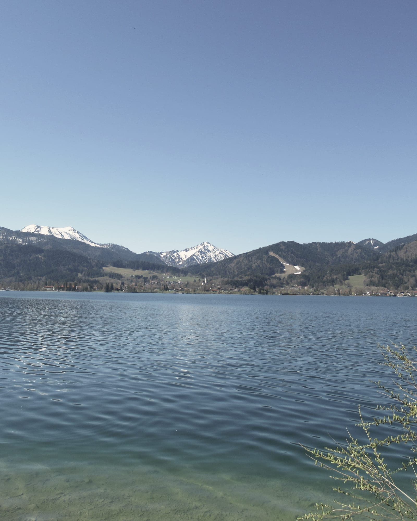 Klares Seewasser mit Bergen am gegenüberliegenden Ufer